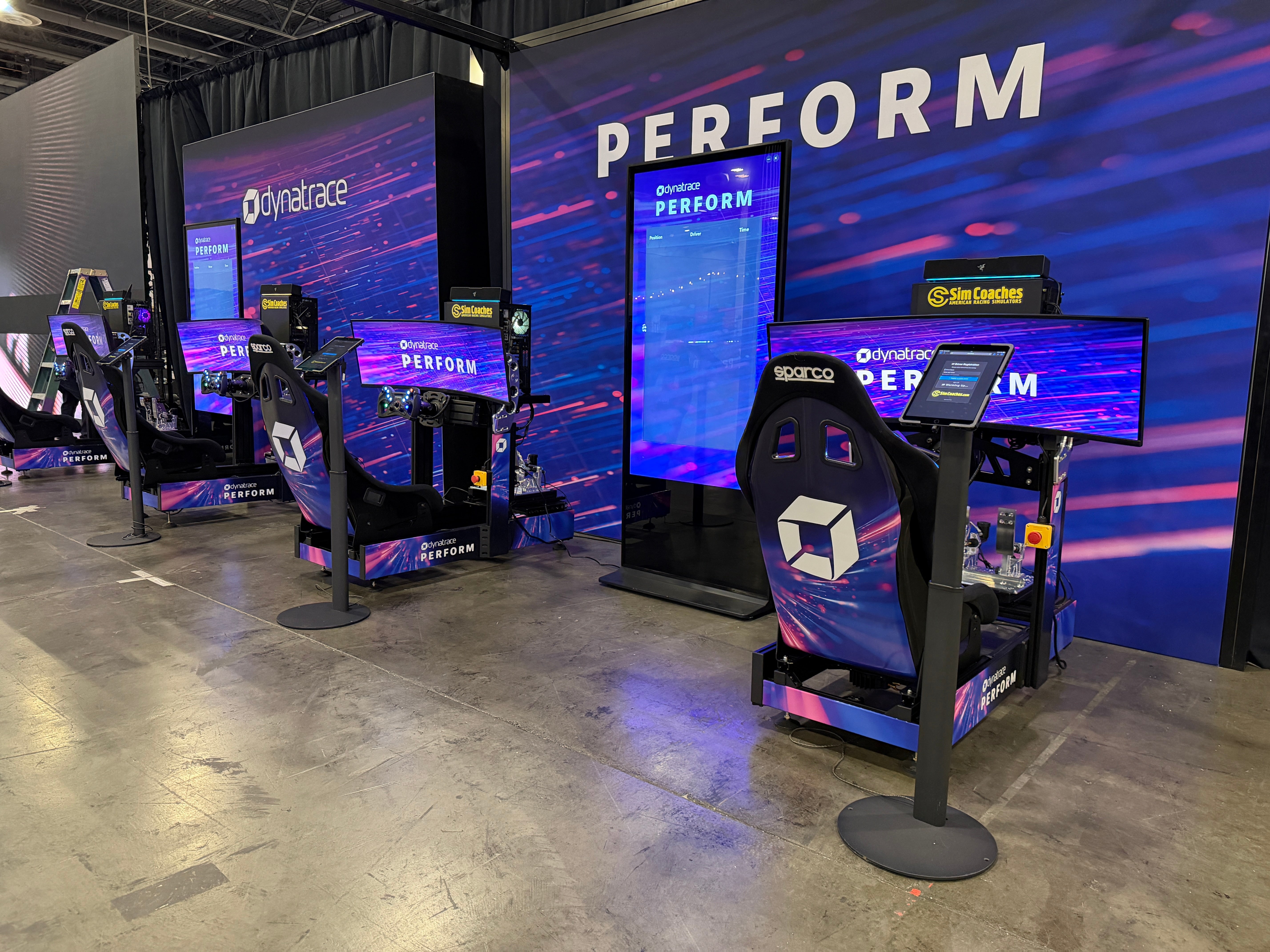 Four wrapped Sim Coaches simulators at Dynatrace Perform
